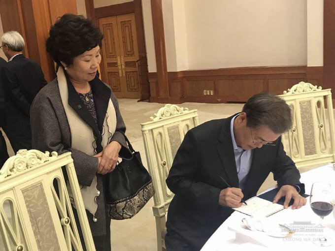 만찬이 끝나고 국회환경미화노조 김영숙 위원장에게 사인해주는 문재인 대통령 | 인스티즈